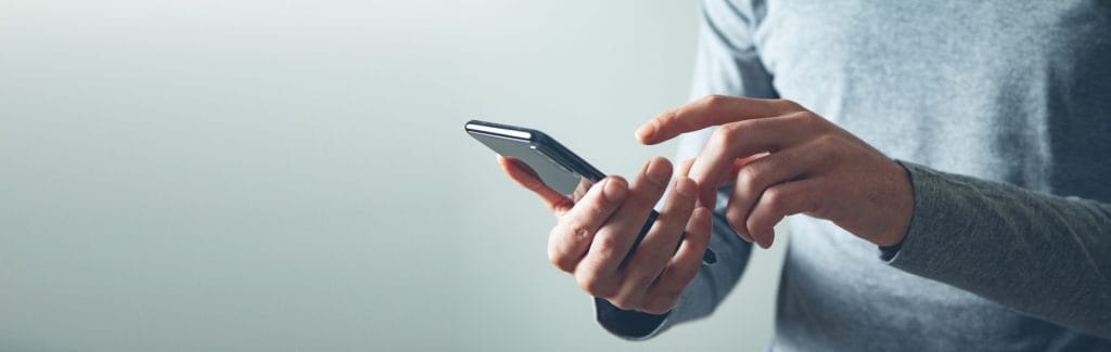 Banner photo of someone holding a phone checking notifications.